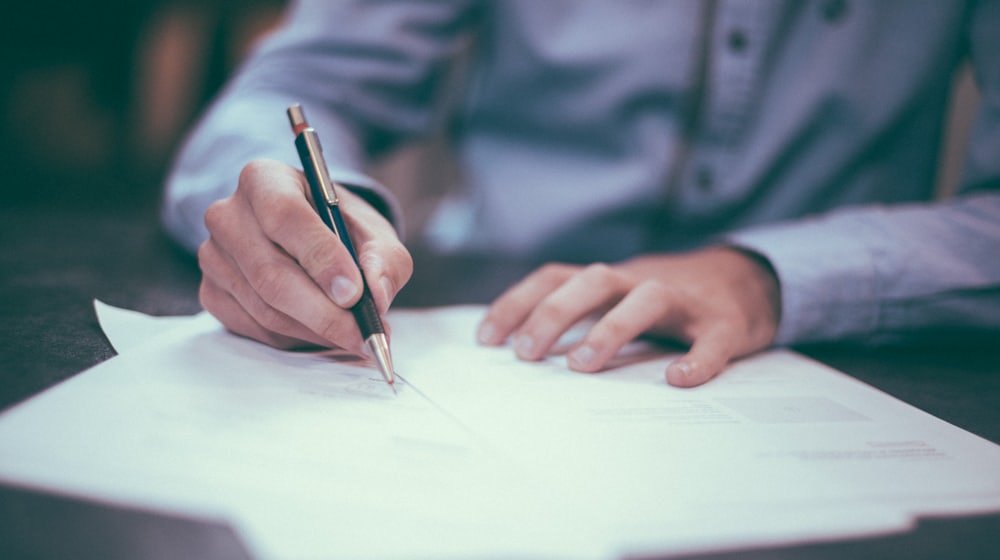 Document de devis et stylo posés sur une table en bois