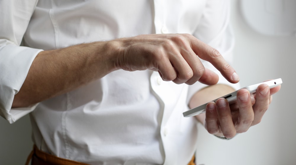 Personne consultant une carte sur son téléphone dans une rue commerçante
