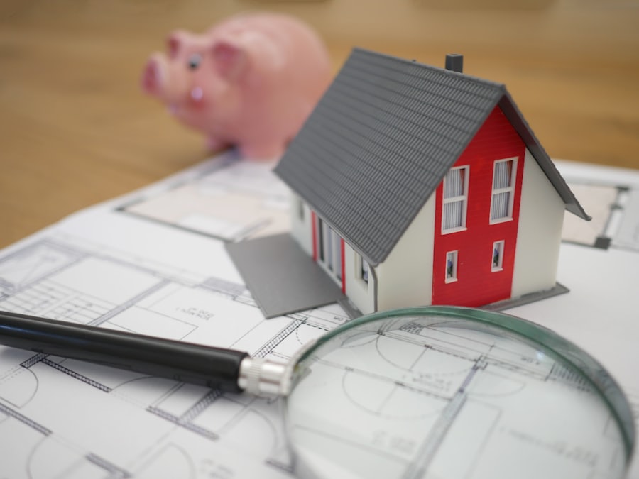 Maquette de maison et loupe posées sur des plans
